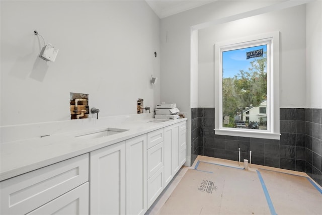 bathroom with vanity and tile walls