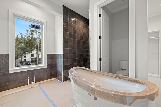 bathroom with toilet, tile walls, and ornamental molding