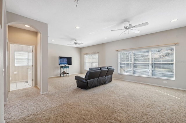 carpeted living room featuring ceiling fan and a healthy amount of sunlight