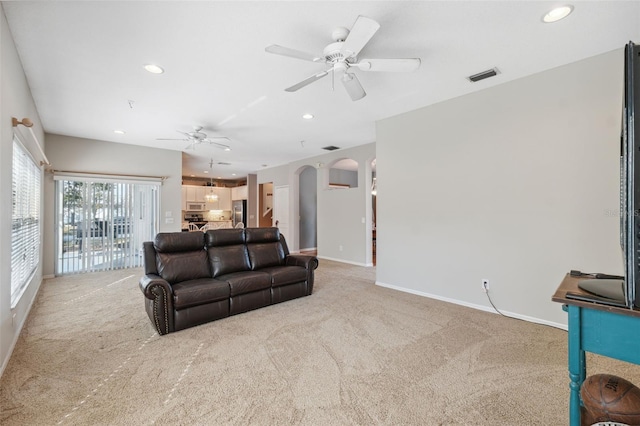 carpeted living room featuring ceiling fan