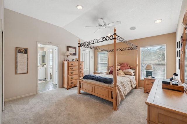 bedroom with vaulted ceiling, connected bathroom, ceiling fan, and light colored carpet