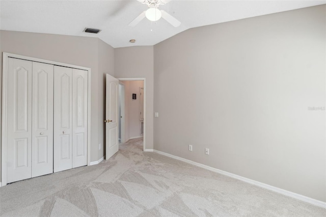 unfurnished bedroom with a closet, ceiling fan, lofted ceiling, and light colored carpet