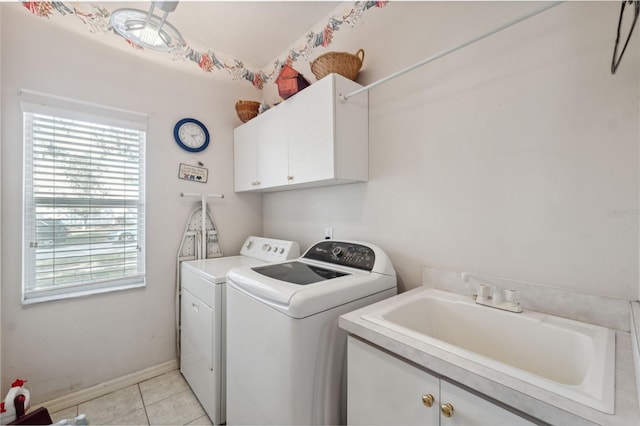 laundry room with light tile patterned floors, sink, washing machine and dryer, and cabinets