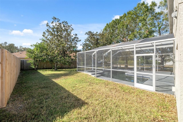 view of yard featuring glass enclosure and a patio area