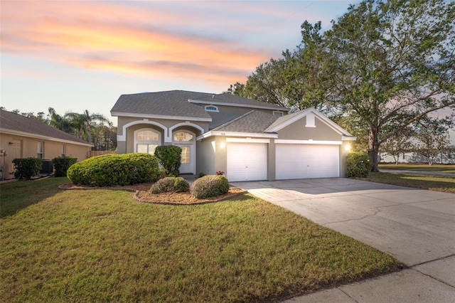 front facade featuring a lawn and a garage