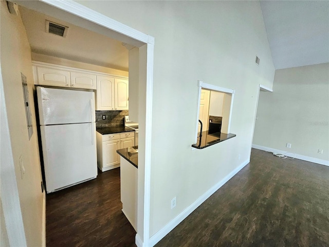 kitchen featuring white cabinetry, white refrigerator, high vaulted ceiling, decorative backsplash, and dark wood-type flooring