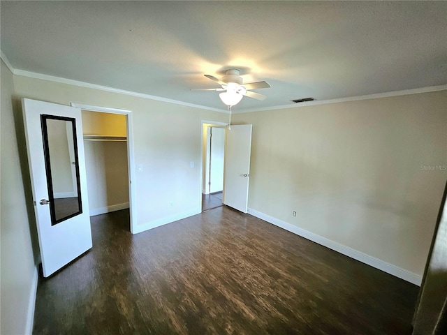 unfurnished bedroom with ornamental molding, ceiling fan, dark hardwood / wood-style floors, and a closet