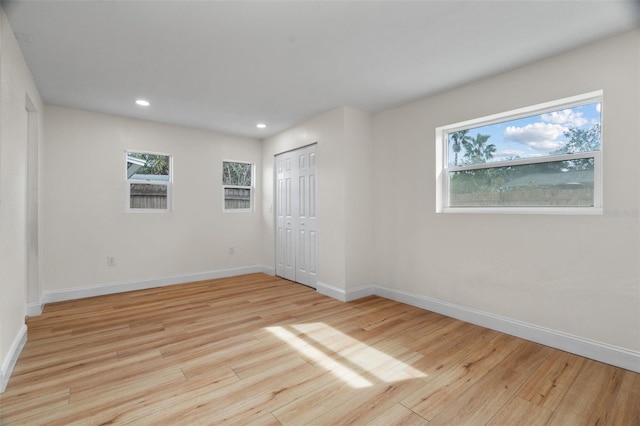 spare room with light hardwood / wood-style flooring and a wealth of natural light