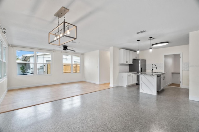 unfurnished living room featuring sink and ceiling fan