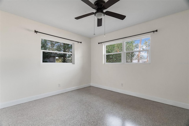 unfurnished room with ceiling fan, speckled floor, and baseboards