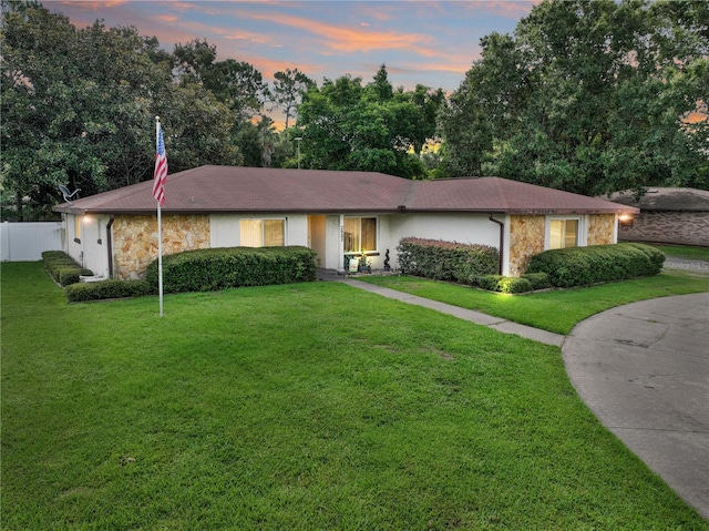 ranch-style home featuring a lawn