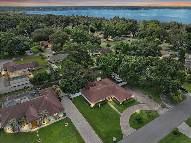 aerial view at dusk featuring a water view