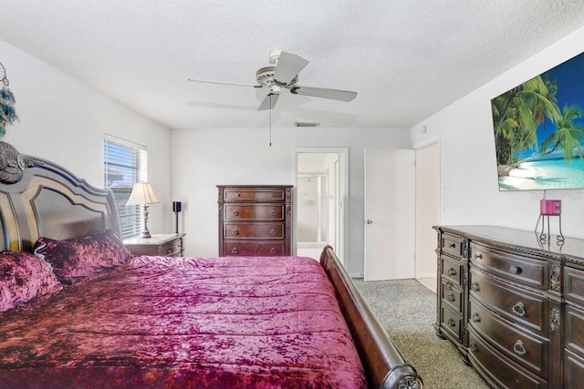 bedroom with ceiling fan, light colored carpet, and a textured ceiling