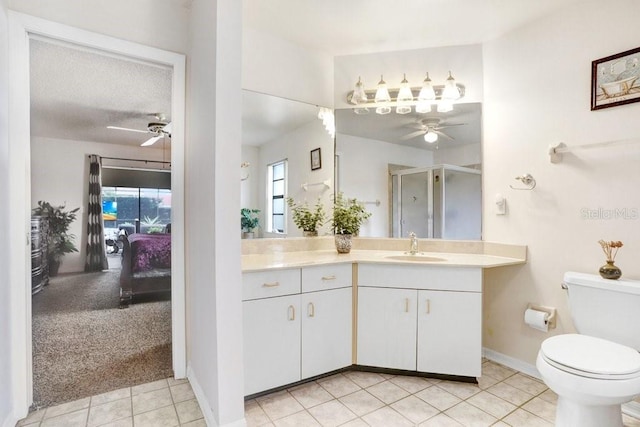 bathroom featuring ceiling fan, tile patterned flooring, toilet, vanity, and a shower with shower door