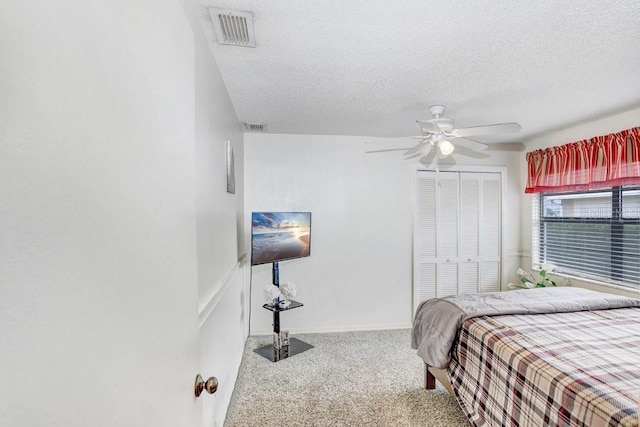 carpeted bedroom featuring a textured ceiling, a closet, and ceiling fan