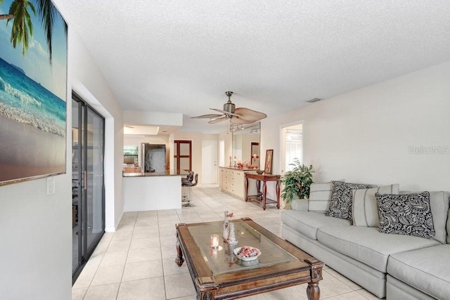 living room with light tile patterned floors, a textured ceiling, and ceiling fan