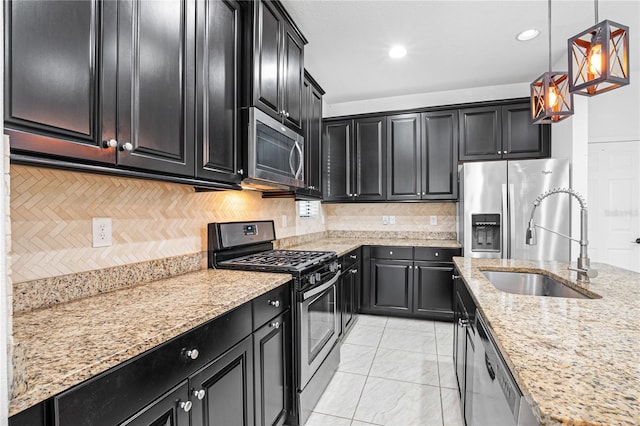 kitchen with light stone countertops, tasteful backsplash, stainless steel appliances, sink, and decorative light fixtures