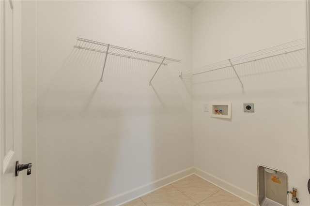 clothes washing area featuring hookup for an electric dryer, hookup for a washing machine, and light tile patterned floors