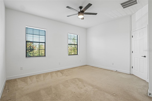 unfurnished room with light colored carpet and ceiling fan