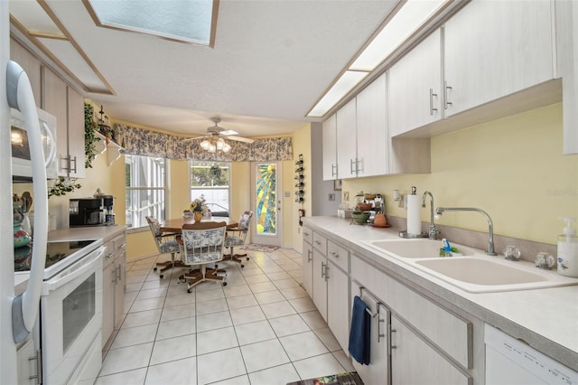 kitchen with ceiling fan, sink, light tile patterned floors, and white appliances