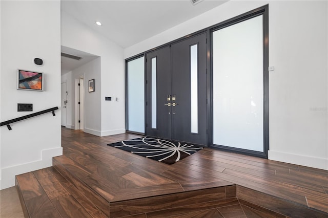 entryway featuring dark wood-type flooring and lofted ceiling