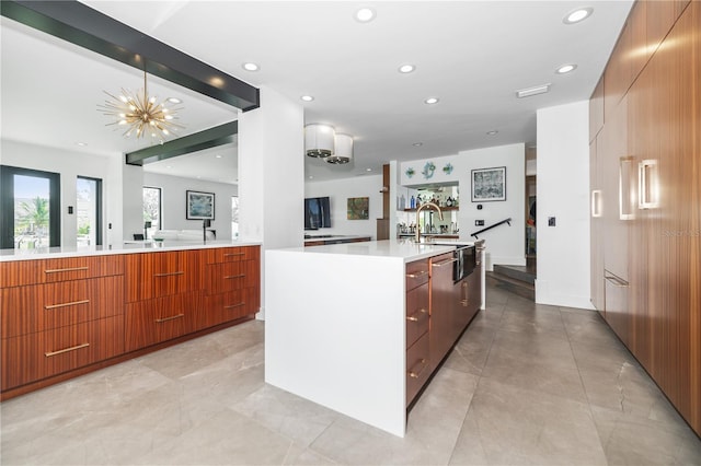 kitchen featuring a center island with sink, decorative light fixtures, and a notable chandelier