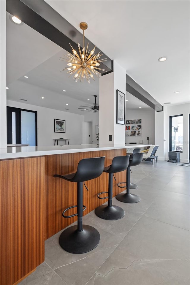 bar featuring ceiling fan with notable chandelier and decorative light fixtures