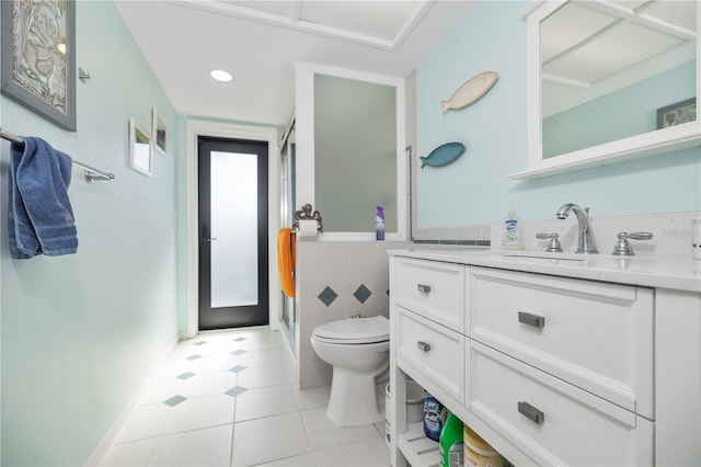 bathroom featuring tile patterned flooring, vanity, toilet, and walk in shower