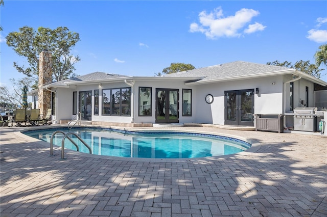 view of pool featuring a grill, a patio area, and french doors