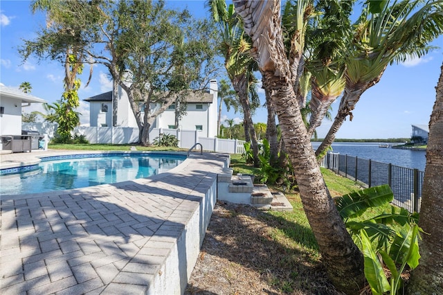 view of swimming pool featuring a patio and a water view