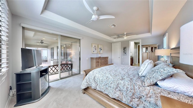 bedroom with ceiling fan, multiple windows, a raised ceiling, and light carpet