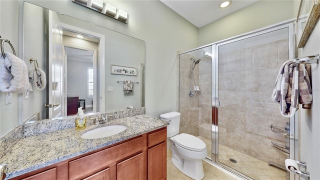 bathroom with vanity, tile patterned floors, a shower with door, and toilet