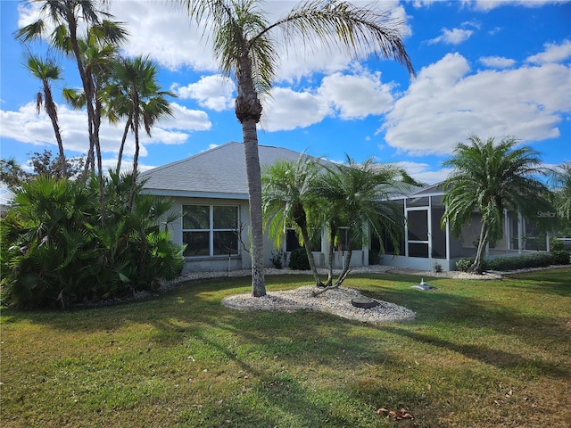 view of front of house featuring glass enclosure and a front lawn