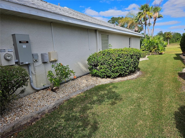 2421 E Del Webb Blvd, Sun City Center, FL 33573 - view of side of property featuring a lawn, stucco siding, and a shingled roof