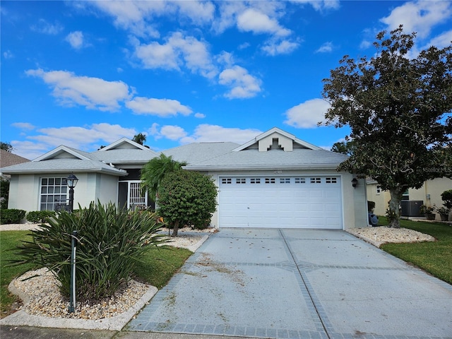 ranch-style home featuring central AC unit and a garage