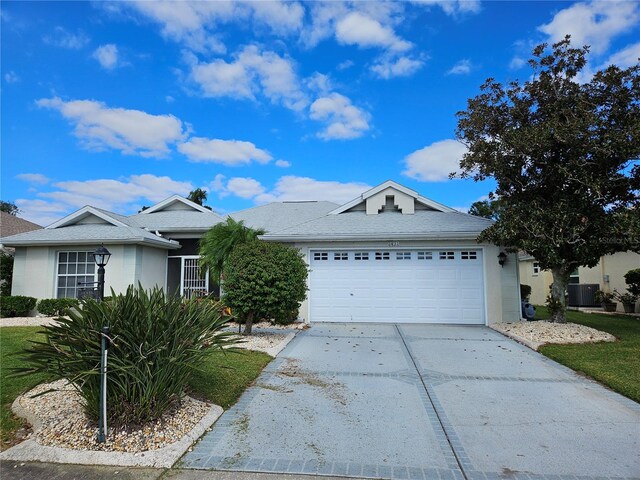 2421 E Del Webb Blvd, Sun City Center, FL 33573 - ranch-style home with central air condition unit, driveway, a garage, and stucco siding
