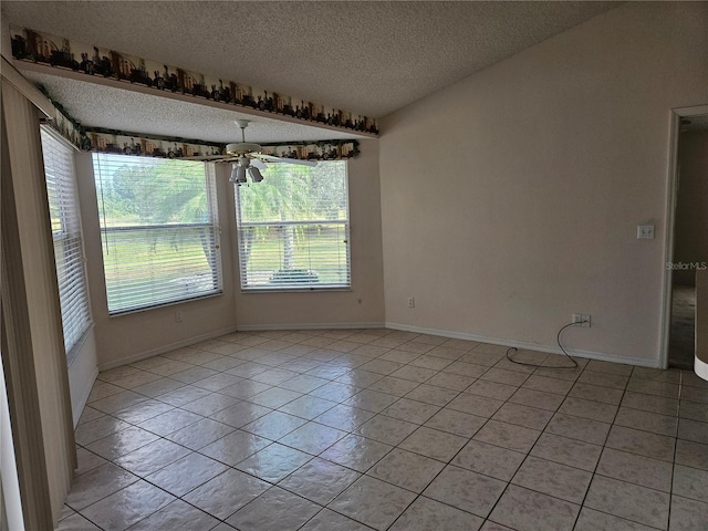 interior space featuring plenty of natural light, light tile patterned flooring, a textured ceiling, and ceiling fan