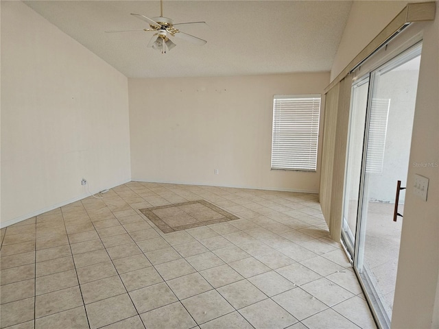 unfurnished room featuring ceiling fan, light tile patterned floors, a textured ceiling, and vaulted ceiling