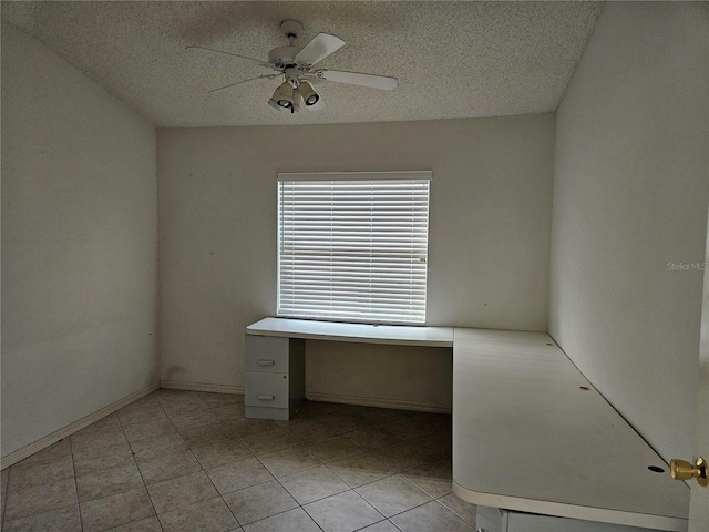 unfurnished room featuring ceiling fan, light tile patterned flooring, and a textured ceiling