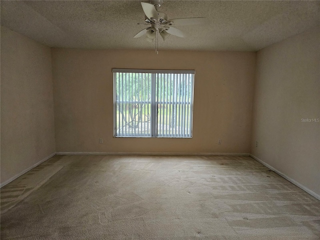 unfurnished room featuring a textured ceiling, light colored carpet, and ceiling fan