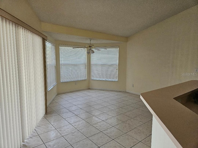 unfurnished dining area featuring light tile patterned floors, a textured ceiling, and ceiling fan