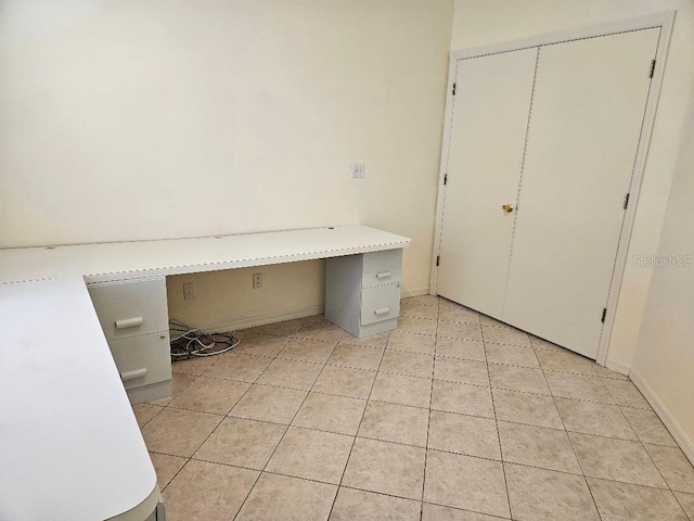 unfurnished office featuring light tile patterned floors