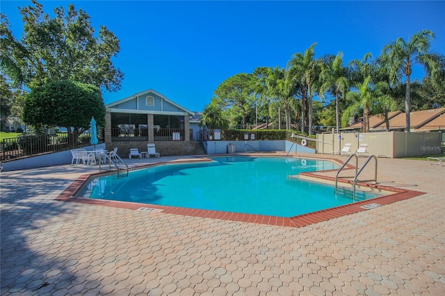 view of pool featuring a sunroom and a patio area