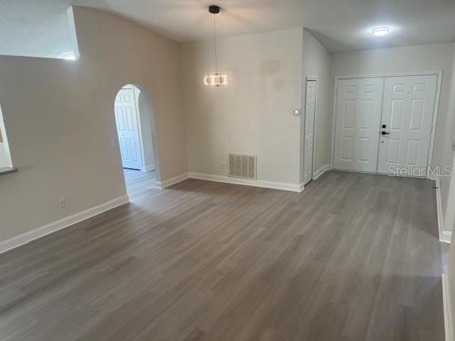 unfurnished room featuring hardwood / wood-style floors and a chandelier