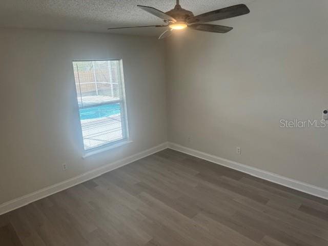 unfurnished room featuring vaulted ceiling, ceiling fan, dark hardwood / wood-style flooring, and a textured ceiling