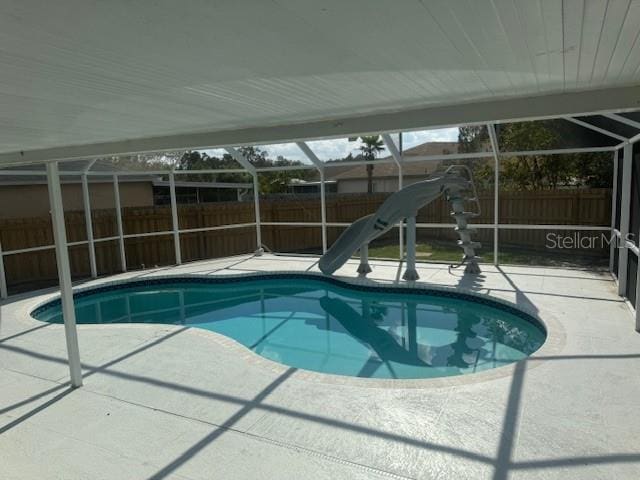 view of pool with a lanai, a patio area, and a water slide