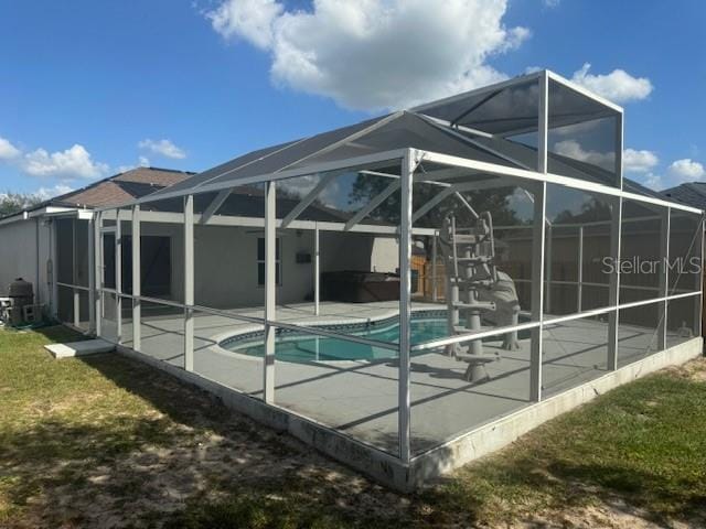 rear view of house with a patio area, a lanai, and a lawn