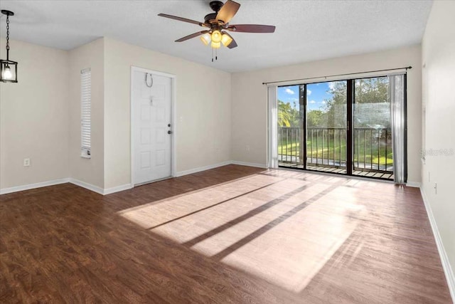 spare room with a textured ceiling, dark hardwood / wood-style floors, and ceiling fan