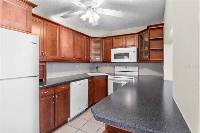 1127 Pine Ridge Cir W Unit A2, Tarpon Springs, FL 34688 - kitchen with white appliances, a sink, a ceiling fan, backsplash, and glass insert cabinets