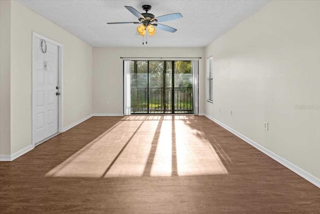 unfurnished room with a textured ceiling, ceiling fan, and dark wood-type flooring